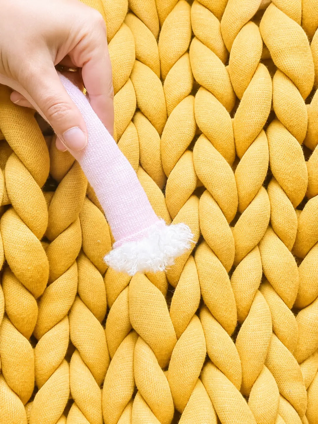 chunky tube yarn texture sample in yellow knitted chunky blanket on background