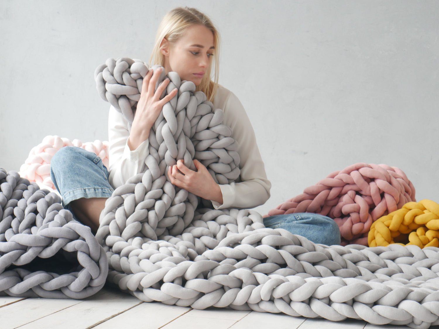 Girl holding knitted blanket on the floor