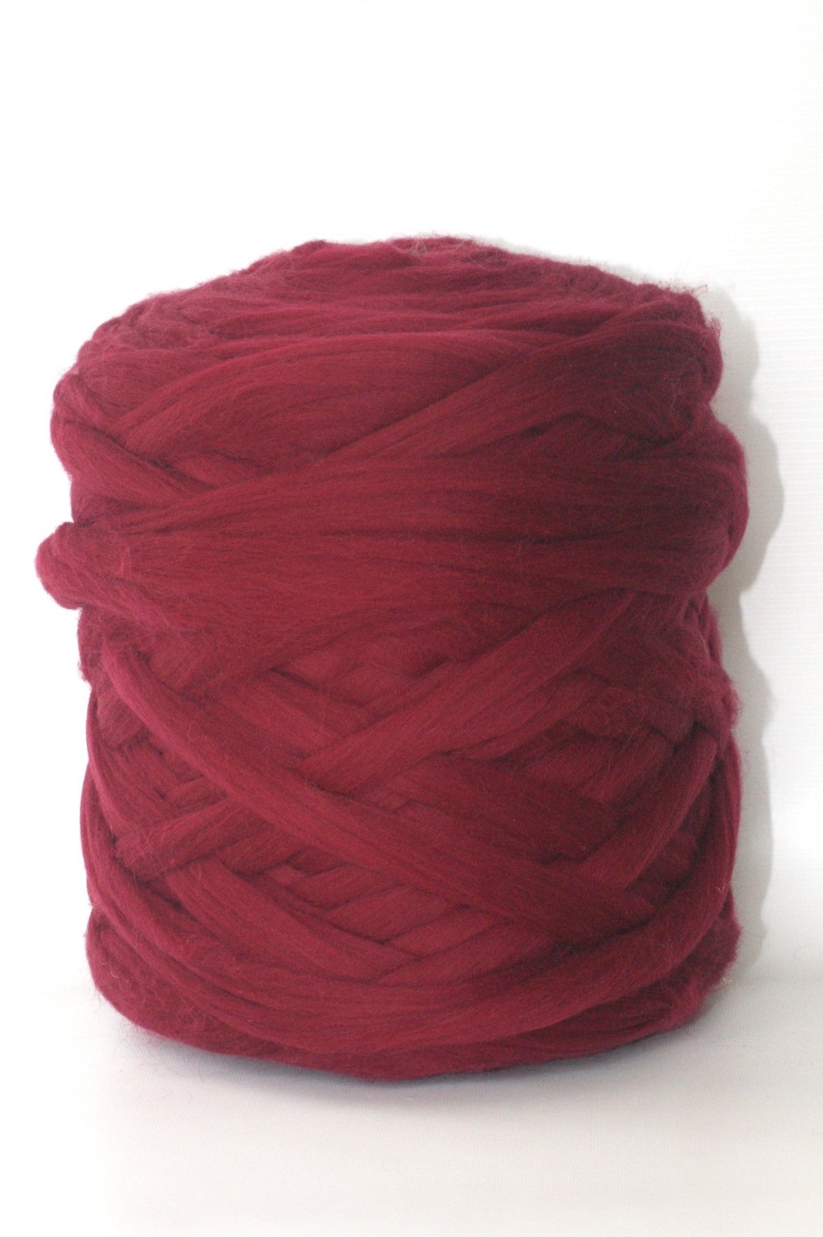 Burgundy ball of chunky wool yarn on a white background