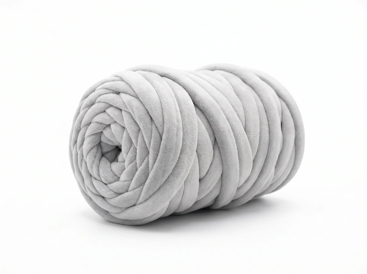 A light gray chunky velvet tube yarn ball, photographed on a seamless white background.