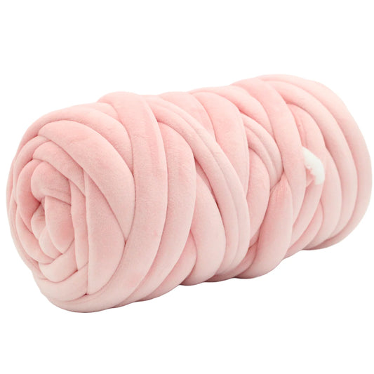 A light pink plush velvet tube yarn rolled into a cylindrical shape, shown against a plain white background.