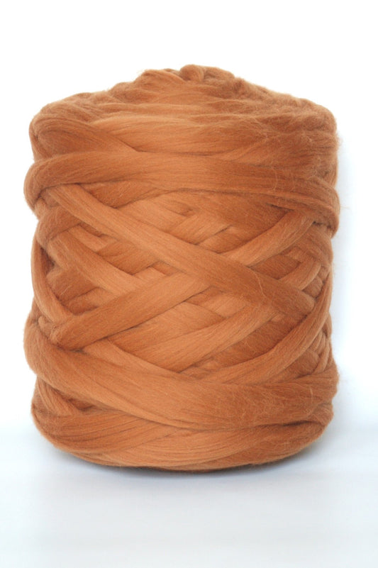 Ginger chunky wool yarn ball on a white background
