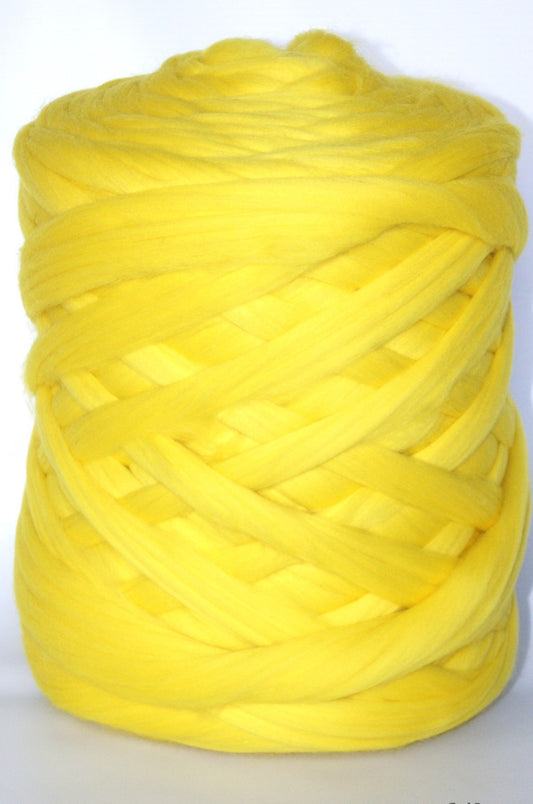 Large ball of lemon chunky wool yarn on a white background