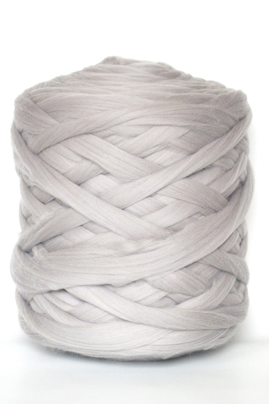 Ball of light  gray chunky wool yarn on a white background