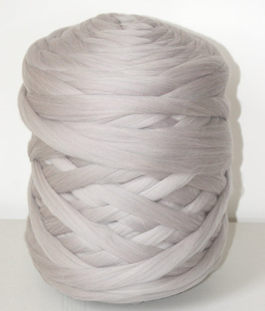 Large ball of lilac gray chunky wool yarn on a white background