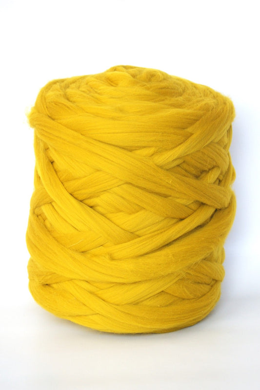 mustard chunky wool yarn ball on a white background