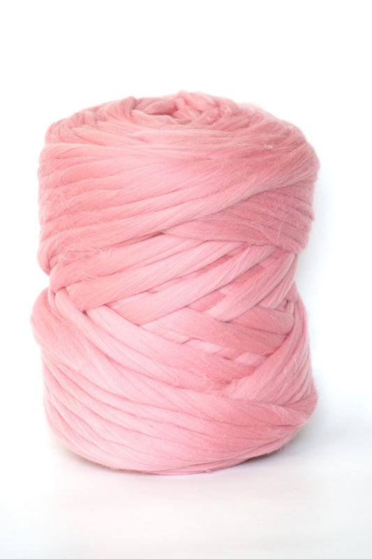 Powder pink chunky wool yarn ball on a white background