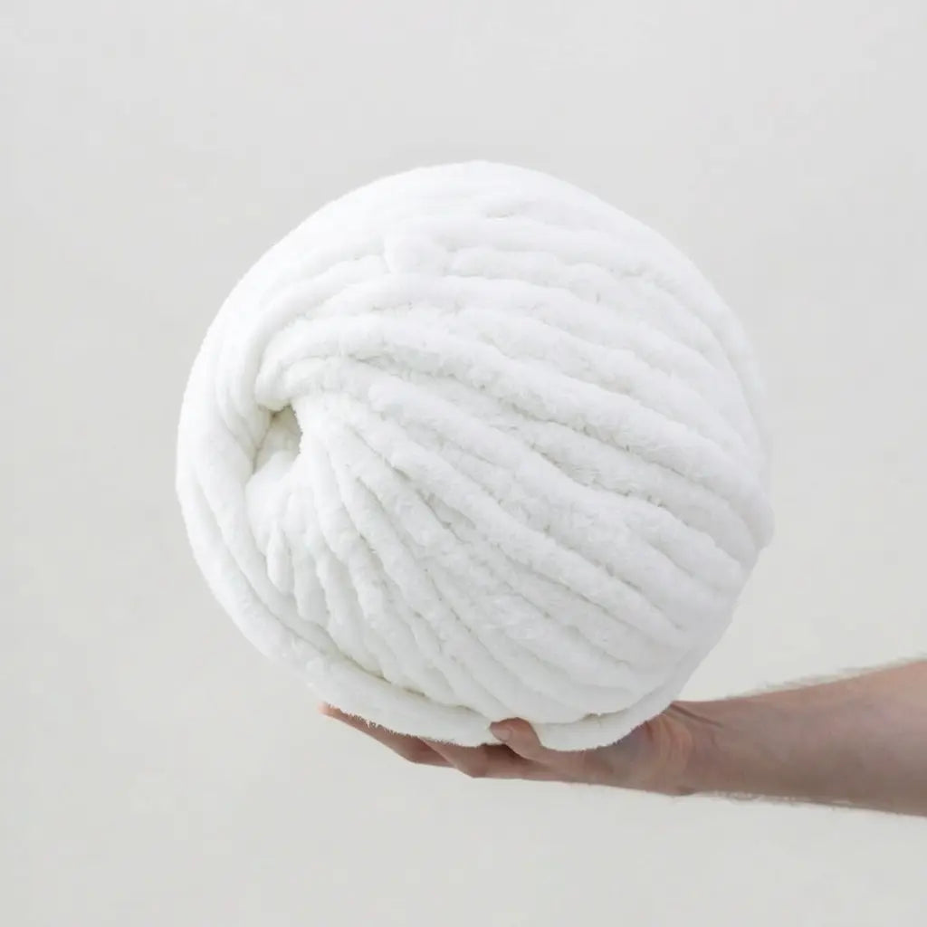 Man hold giant snow white color chenille yarn on white  background