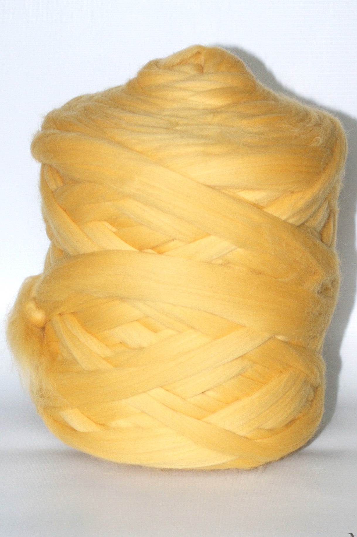 yellow chunky wool yarn ball on a white background